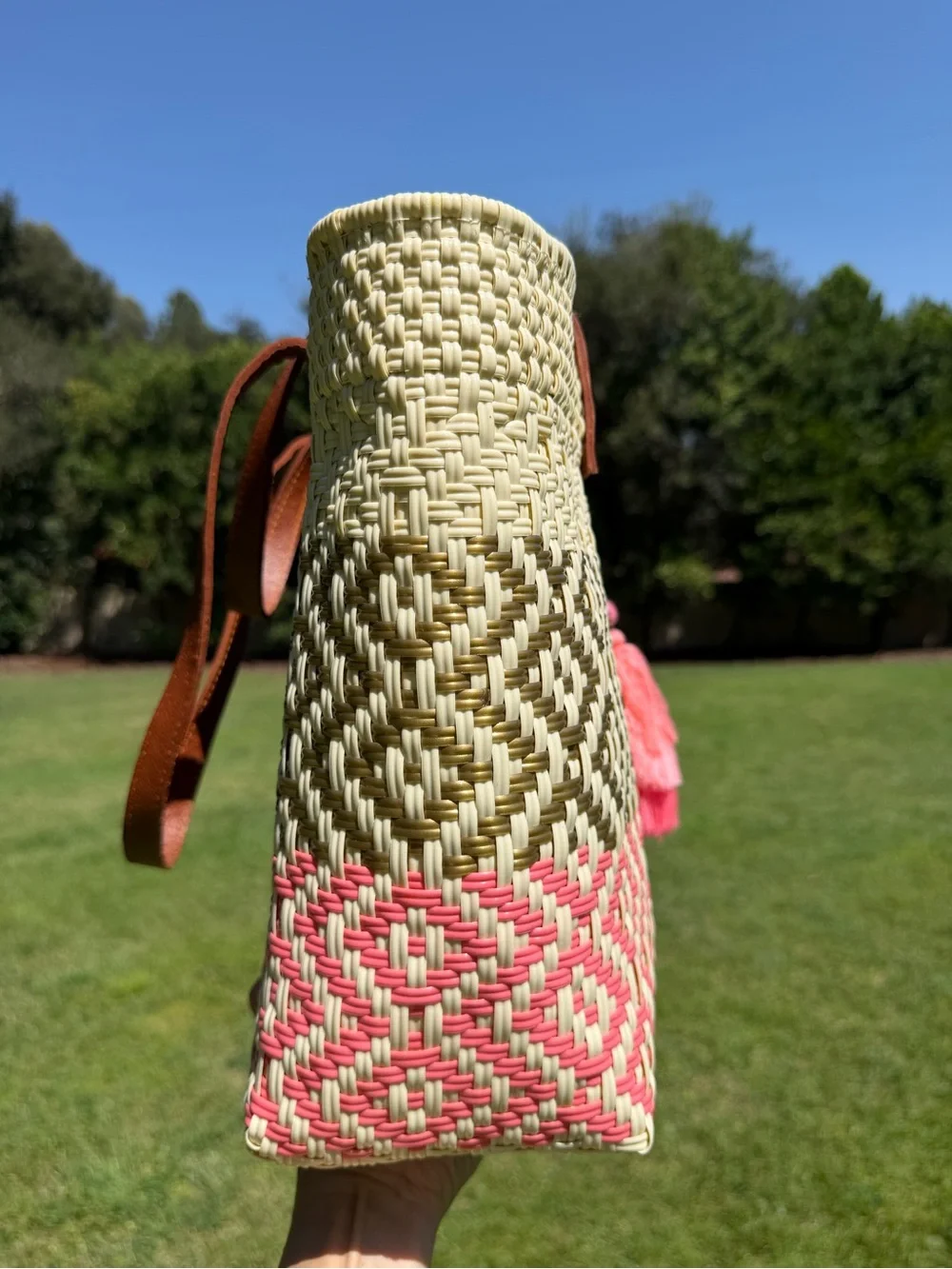 Woven Straw Tote Bag with Brown Leather Handles and Pink Tassel Accent